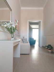 a living room with a white couch and a vase of flowers at Casa ERMES 151 in Floridia