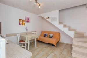 Sala de estar con silla, mesa y escaleras en Apartments Lovro en Dubrovnik