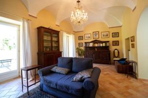 uma sala de estar com um sofá azul e um lustre em La loggia dei frati em Cannero Riviera