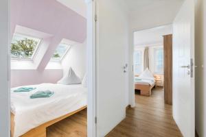 ein weißes Schlafzimmer mit einem Bett und einem Fenster in der Unterkunft Ferienhaus Drachenflieger Pepelow in Pepelow