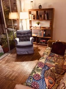 a living room with a chair and a rug at Penthouse Malva Rosa in Montevideo