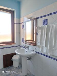 a bathroom with a sink and a toilet and a window at Agriturismo Mandriagiumenta in Caltavuturo