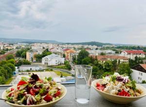 a table with two bowls of salad and a glass of water at Conest Vision Studio in Iaşi