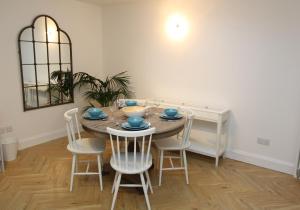 a dining room with a table with chairs and a mirror at City Centre Contemporary New Town Flat in Edinburgh