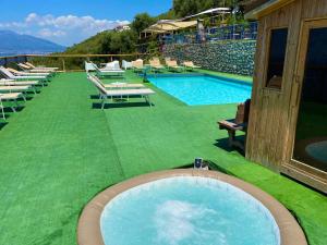 a large swimming pool with chairs and a person sitting next to it at Corte Degli Ulivi Resort in Vico Equense +104 photos