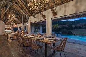 a dining room with a table and chairs and a pool at Ferney Nature Lodge in Mahébourg