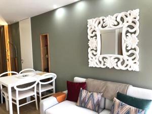 ein Wohnzimmer mit einem Sofa und einem Spiegel in der Unterkunft Vila do Conde - Os Maias in Vila do Conde