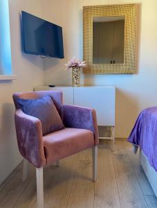 salon z fioletowym krzesłem i lustrem w obiekcie Golden Sunset 2 w mieście Nijvice