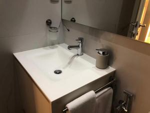 un lavandino bianco in un bagno con uno specchio di Vila do Conde - Os Maias a Vila do Conde Altre 8 foto