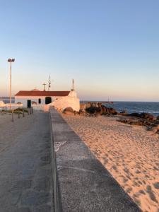 einen Fußweg an einem Strand neben dem Meer in der Unterkunft Vila do Conde - Os Maias in Vila do Conde