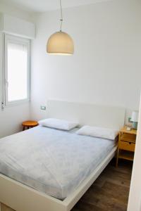 a white bedroom with a large bed and a window at El Palmar Residence Vista-Mare e Vista-Piscina in Lido di Jesolo +23 photos
