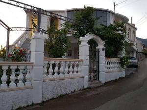 a white fence in front of a house at Guest house Nina in Bar