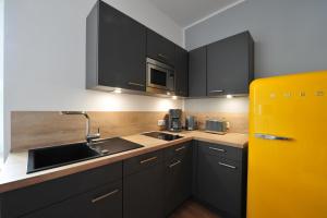 a kitchen with black cabinets and a yellow refrigerator at Appartm. Schwarzen Pfuhl in Willich +2 photos