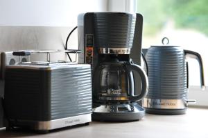 a coffee maker and cups sitting on a counter at Appartm. Schwarzen Pfuhl in Willich