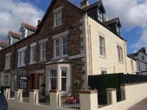 a large brick building with a fence in front of it at Salisbury Guest House in Keswick