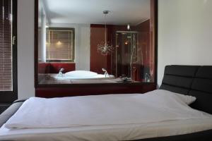 a bedroom with a bath tub and a large mirror at Villa Čengić in Sarajevo +91 photos