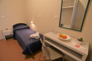 a room with a bed and a table with a bowl of fruit at Hotel Fedora Rimini in Rimini