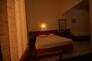 A bed or beds in a room at Lena Hotel