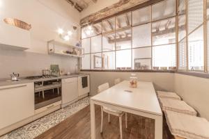 a kitchen with a white table and chairs and windows at casa sangiacomo quattro in Modena
