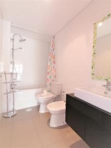 bagno bianco con servizi igienici e lavandino di Paraiso Sol Rocha Luxurious beach apartment a Portimão