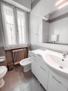 a white bathroom with a sink and a toilet at Casa Vacanze Annarita in Bardolino