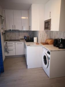 kuchnia z białymi szafkami i pralką w obiekcie Galeb Apartments osjecka ulica 37 w Puli
