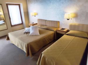 una camera d'albergo con due letti e due lampade di Hotel Dependance Silvestro a Garda