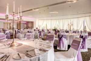 ラーンにあるバリーギャリー キャッスルの白いテーブルと紫色の椅子が備わる宴会場