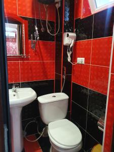 Baño rojo con aseo y lavamanos en Hotel Exotica, en Ureki