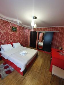 - une chambre avec un lit et un mur rouge dans l'établissement Hotel Exotica, à Ureki