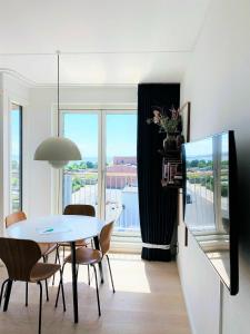 jadalnia ze stołem i krzesłami oraz oknem w obiekcie ApartmentInCopenhagen Apartment 1453 w Kopenhadze