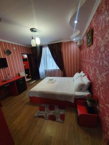 um quarto com uma cama e uma parede vermelha em Hotel Exotica em Ureki