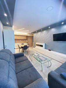 a living room with a couch and a table at Апартамент на няколко минути от Летището in Sofia