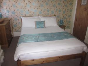 a bedroom with a large white bed with blue flowers at The Old Town Bed and Breakfast in Hastings