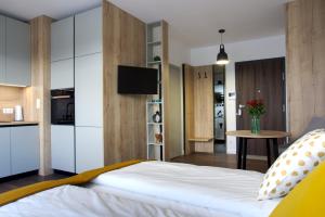 Un dormitorio con una cama grande y una mesa pequeña. en Essence Apartments Topaz, en Poznan