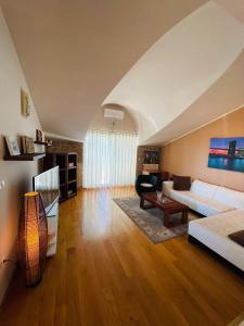 sala de estar con sofá blanco y mesa en Apartments Toma, en Novalja