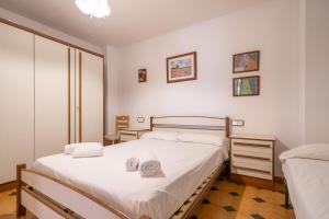 1 dormitorio con 2 camas y toallas. en HomeHolidaysRentals Tarongers, en Pineda de Mar