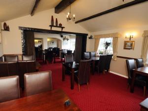 a dining room with wooden tables and chairs at Rusland Pool Hotel in Bouth