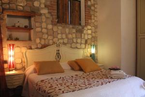 ein Schlafzimmer mit einem weißen Bett und einer Steinmauer in der Unterkunft Il Debbio in Riccò del Golfo di Spezia