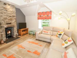 uma sala de estar com um sofá e uma lareira em 2 Cae Mattw em Abergele