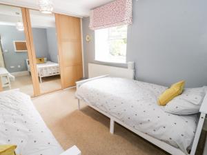 a small bedroom with a bed and a mirror at 2 Cae Mattw in Abergele