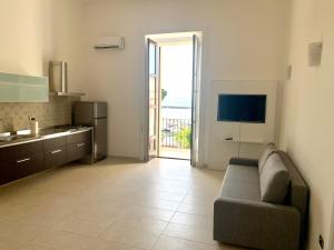 a kitchen and living room with a couch and a television at Luxury apartment Vitruvio in Formia