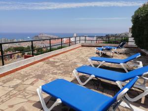 a group of blue lounge chairs on a patio at Apartamentos Vista in Peniscola