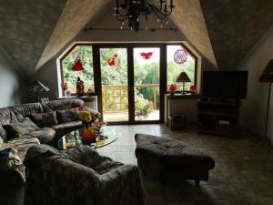 un soggiorno con divani e una grande finestra di Pod Jesionem a Rachanie
