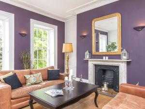 a living room with purple walls and a mirror at 3 Berkeley Square Guesthouse in Bristol