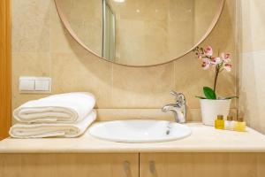 um lavatório de casa de banho com espelho e toalhas em HOMEABOUT FRESCA Apartment I em Málaga