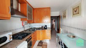 a kitchen with wooden cabinets and a blue counter top at Casa Lena - Sítio da Nazaré in Nazaré