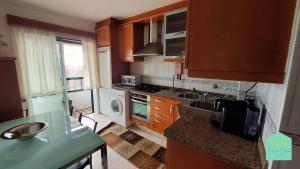 a kitchen with wooden cabinets and a sink and a dishwasher at Casa Lena - Sítio da Nazaré in Nazaré +25 photos