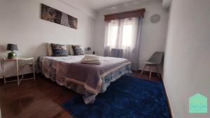 a bedroom with a bed and a blue rug at Casa Lena - Sítio da Nazaré in Nazaré