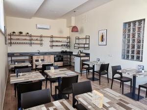 a restaurant with tables and chairs in a room at Le Métro in Carini